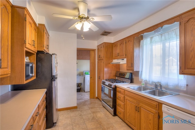 kitchen with washer / dryer, stainless steel appliances, ceiling fan, and sink