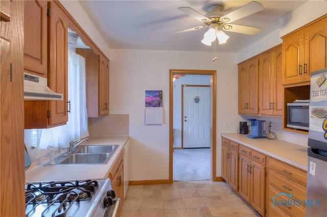 kitchen featuring ventilation hood, ceiling fan, sink, and stainless steel appliances