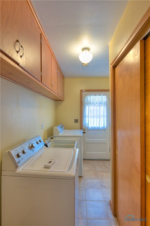 clothes washing area featuring cabinets, separate washer and dryer, and light tile patterned flooring