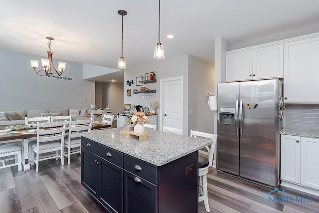 kitchen with white cabinets, dark hardwood / wood-style flooring, stainless steel fridge with ice dispenser, and hanging light fixtures