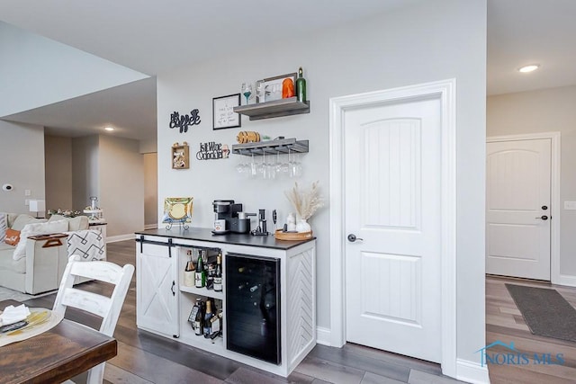 bar featuring dark hardwood / wood-style flooring and beverage cooler