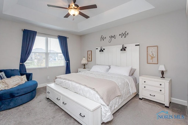 bedroom featuring a tray ceiling, ceiling fan, and light colored carpet