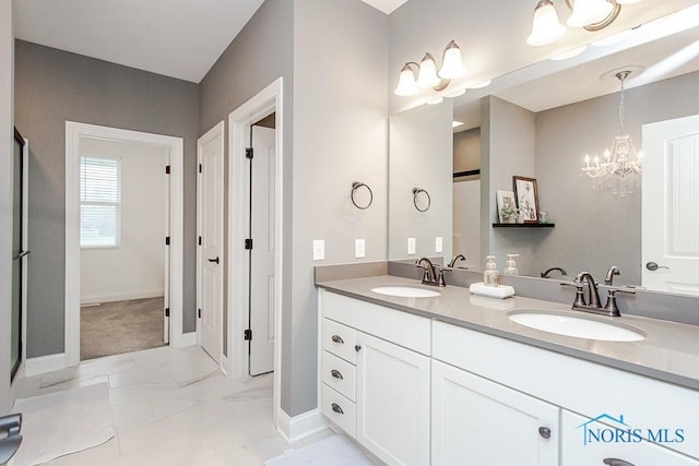 bathroom featuring a notable chandelier and vanity