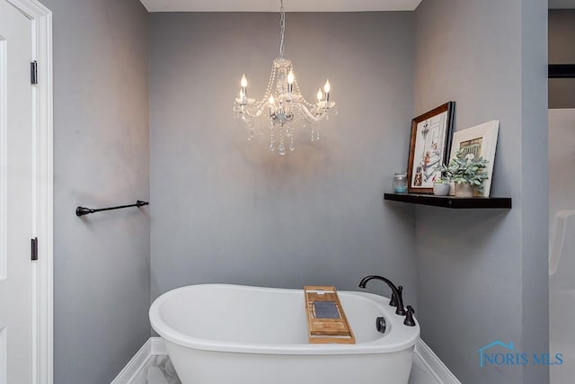 bathroom with a bathtub and a chandelier