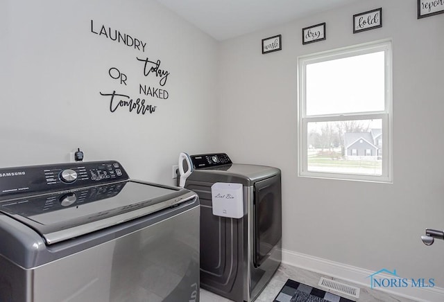 clothes washing area featuring a healthy amount of sunlight and washing machine and dryer