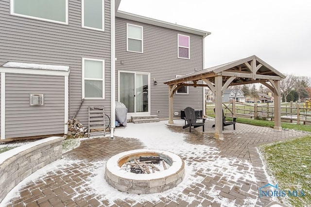 rear view of house with a gazebo, a patio, and an outdoor fire pit