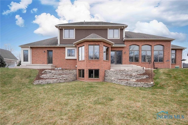 rear view of property featuring a lawn