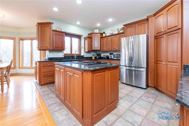 kitchen featuring a kitchen island, dark stone countertops, sink, and appliances with stainless steel finishes