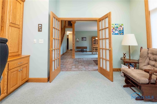 living area with french doors and light colored carpet