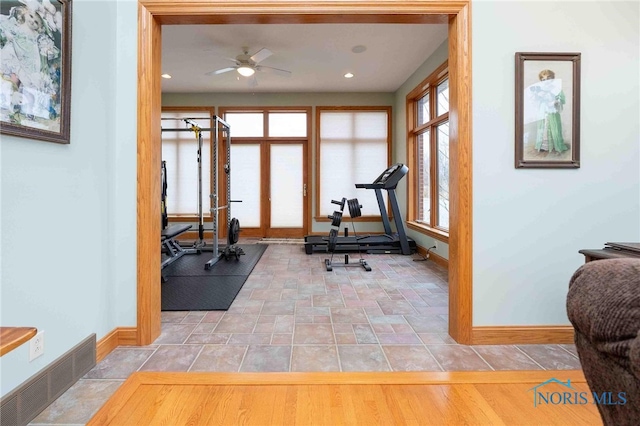 workout area featuring ceiling fan and light hardwood / wood-style floors