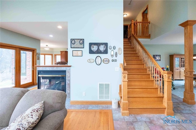 stairs featuring a fireplace and decorative columns