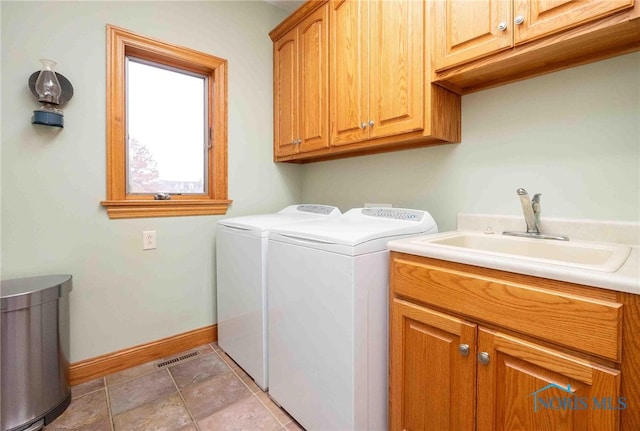 laundry area with sink, light tile patterned floors, cabinets, and independent washer and dryer