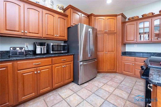 kitchen featuring dark stone countertops and appliances with stainless steel finishes