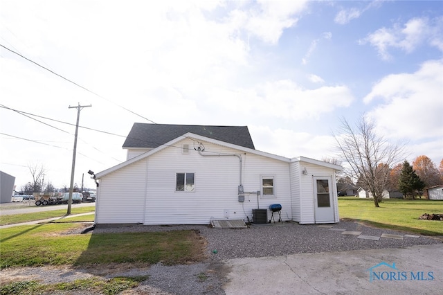 view of property exterior featuring central AC unit and a lawn