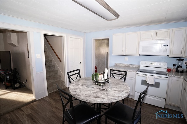 kitchen featuring light stone counters, white cabinets, dark wood-type flooring, and white appliances