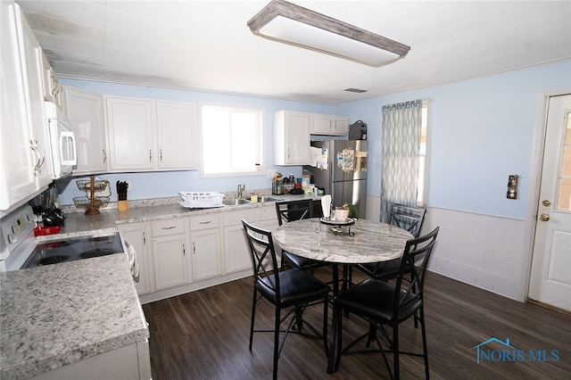 kitchen with stainless steel fridge, stove, and white cabinets