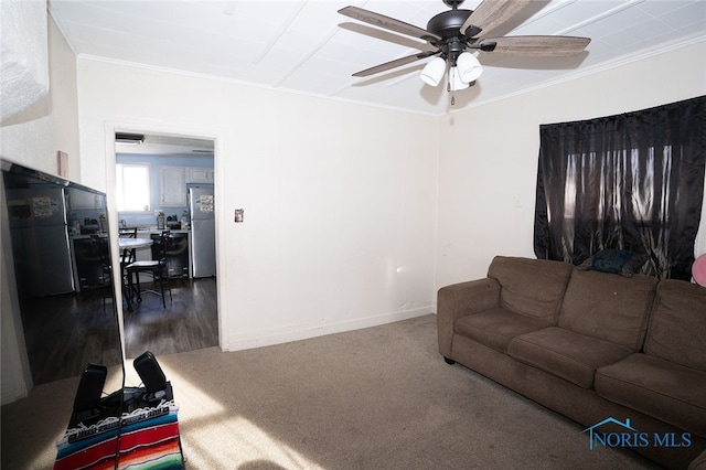 living room featuring hardwood / wood-style floors, ceiling fan, and crown molding