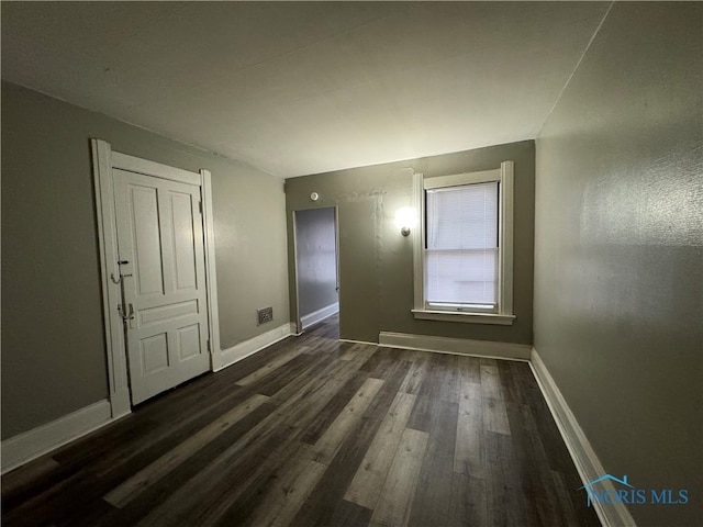 unfurnished room featuring dark hardwood / wood-style flooring