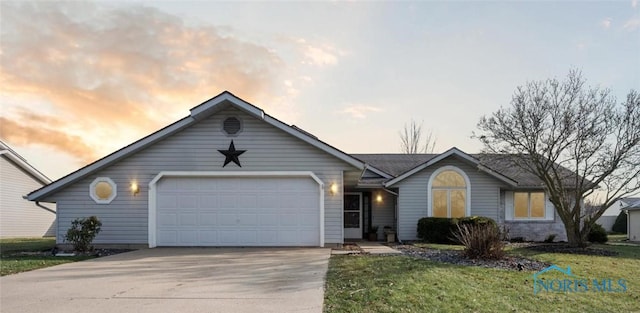 ranch-style house with a garage and a lawn