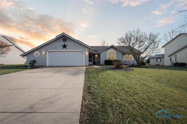 ranch-style house with a yard and a garage