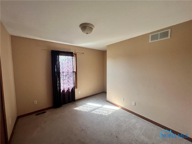 spare room featuring light colored carpet