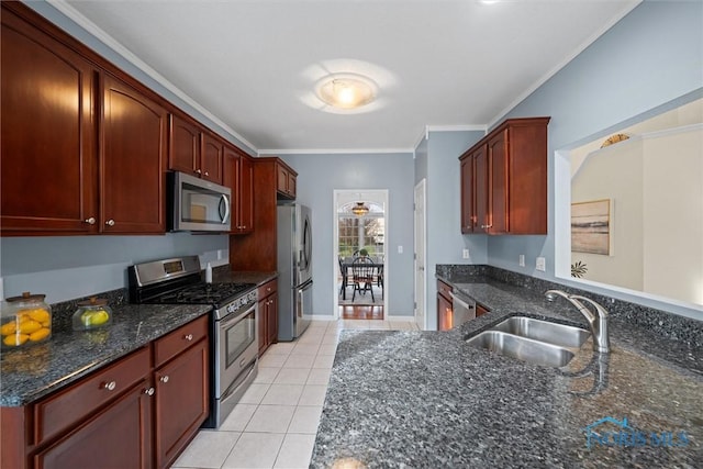 kitchen with sink, dark stone countertops, crown molding, light tile patterned flooring, and appliances with stainless steel finishes