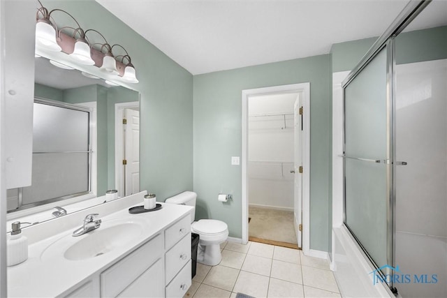 full bathroom with tile patterned floors, vanity, bath / shower combo with glass door, and toilet