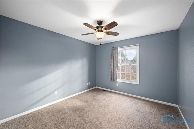 carpeted spare room featuring ceiling fan