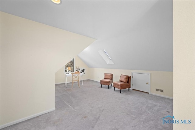 sitting room featuring light carpet and lofted ceiling with skylight