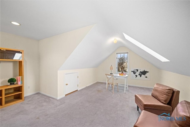 interior space featuring light carpet and lofted ceiling with skylight