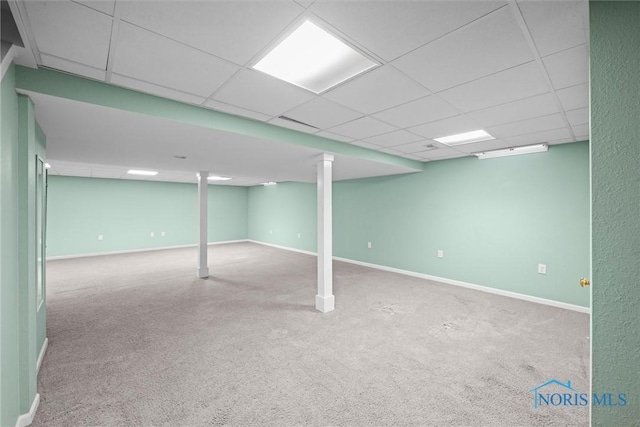 basement with a paneled ceiling and carpet flooring