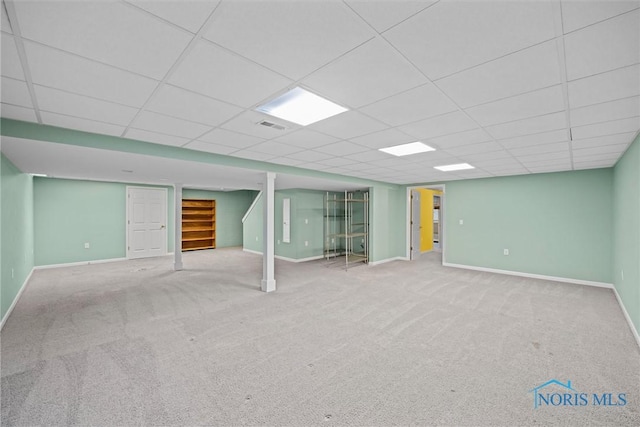 basement featuring carpet flooring and a paneled ceiling