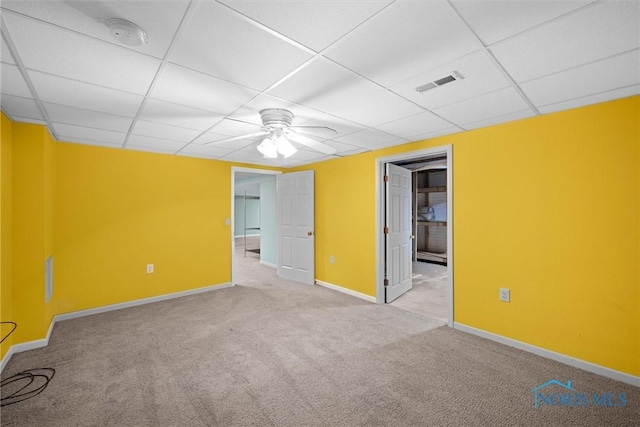 carpeted empty room with a paneled ceiling and ceiling fan