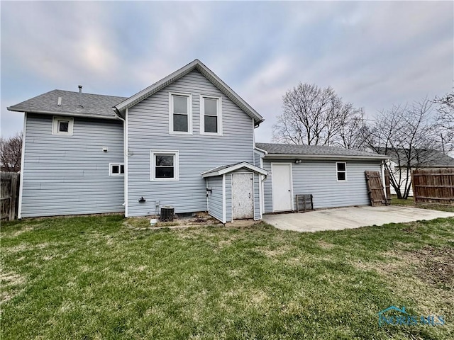 rear view of property with a yard, cooling unit, and a patio