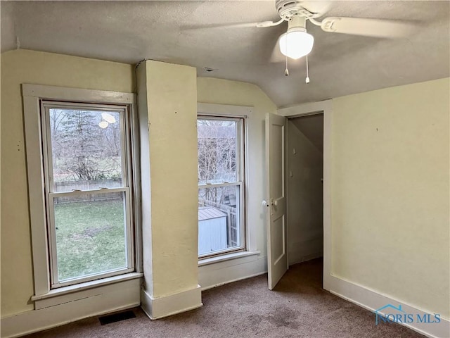 interior space featuring carpet, a wealth of natural light, ceiling fan, and lofted ceiling