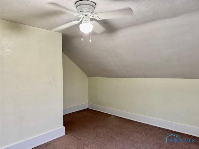 bonus room with dark colored carpet, ceiling fan, lofted ceiling, and a textured ceiling