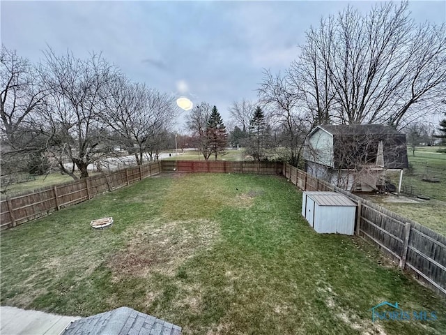 view of yard featuring a shed and an outdoor fire pit