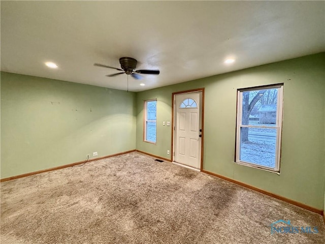 carpeted entrance foyer featuring ceiling fan