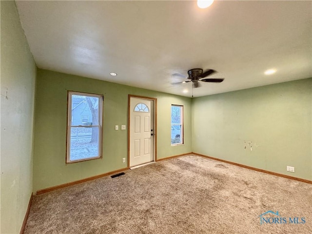 carpeted foyer entrance featuring ceiling fan