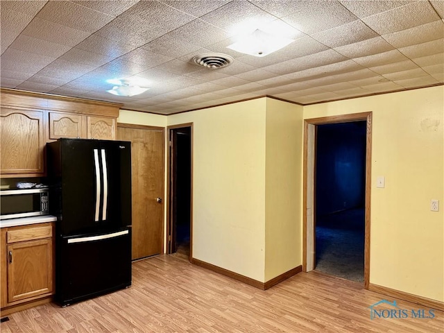 kitchen featuring black refrigerator and light hardwood / wood-style floors