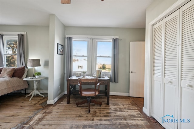 home office featuring a wealth of natural light and dark wood-type flooring