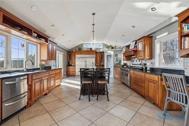 kitchen featuring a center island, hanging light fixtures, vaulted ceiling, light tile patterned floors, and premium appliances