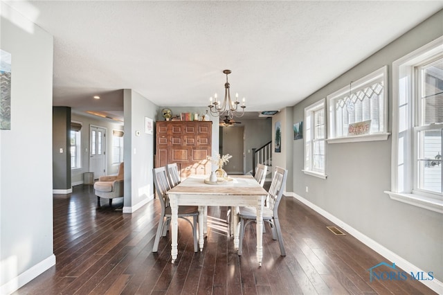 dining space with plenty of natural light, a chandelier, and dark hardwood / wood-style floors