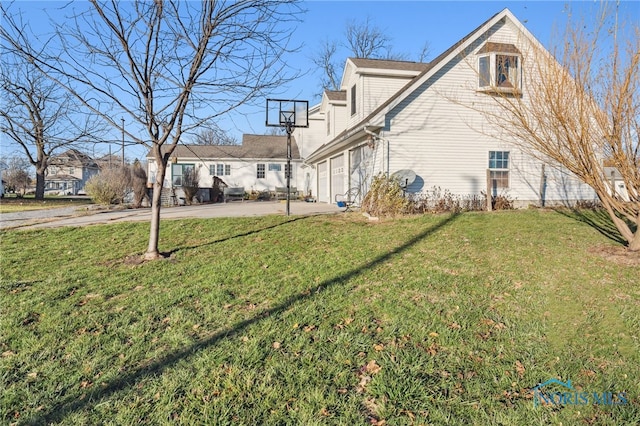 view of side of home featuring a lawn and a garage