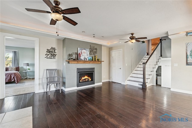 unfurnished living room with dark hardwood / wood-style floors and ceiling fan