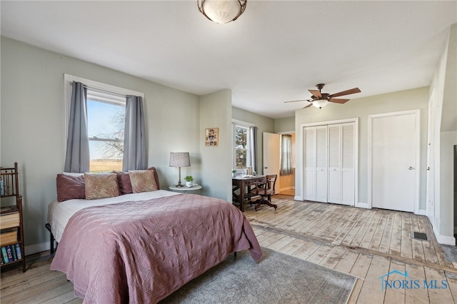 bedroom featuring hardwood / wood-style flooring, ceiling fan, and multiple windows