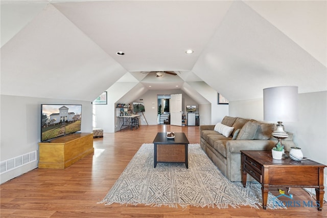 living room featuring light hardwood / wood-style floors and vaulted ceiling