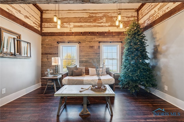 living room with beamed ceiling, dark hardwood / wood-style floors, and wood walls