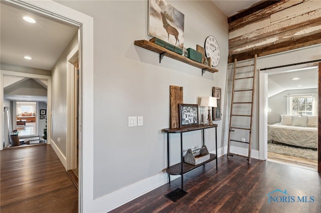 hall featuring lofted ceiling and dark wood-type flooring