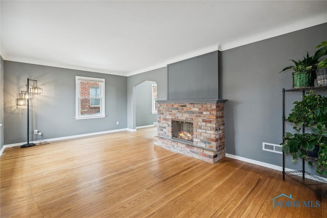 unfurnished living room with light wood-type flooring and a fireplace